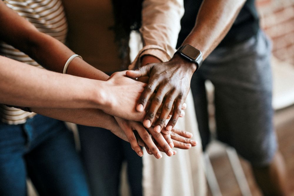 group of diverse people stacking hands